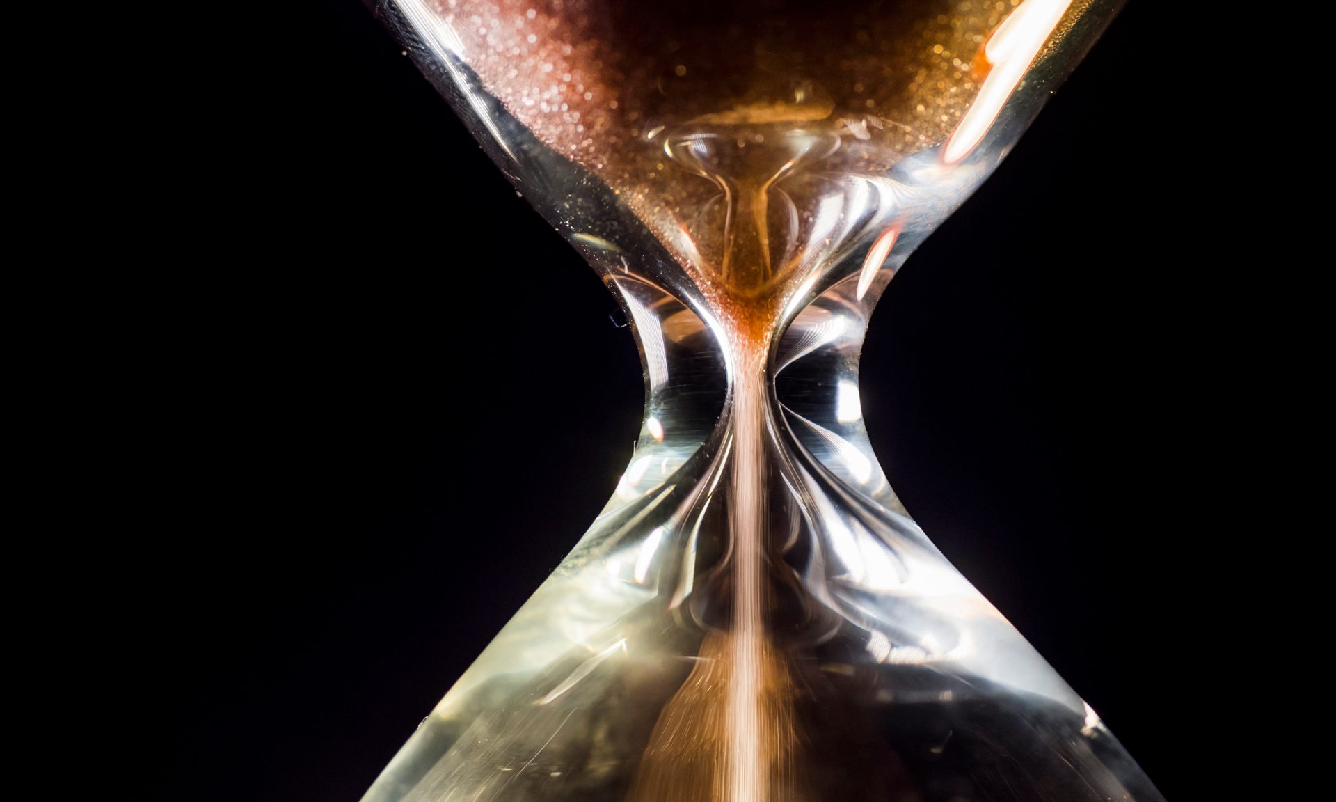 Tiimalasin keskikohta, jossa valuu hiekkaa ylhäältä alas.