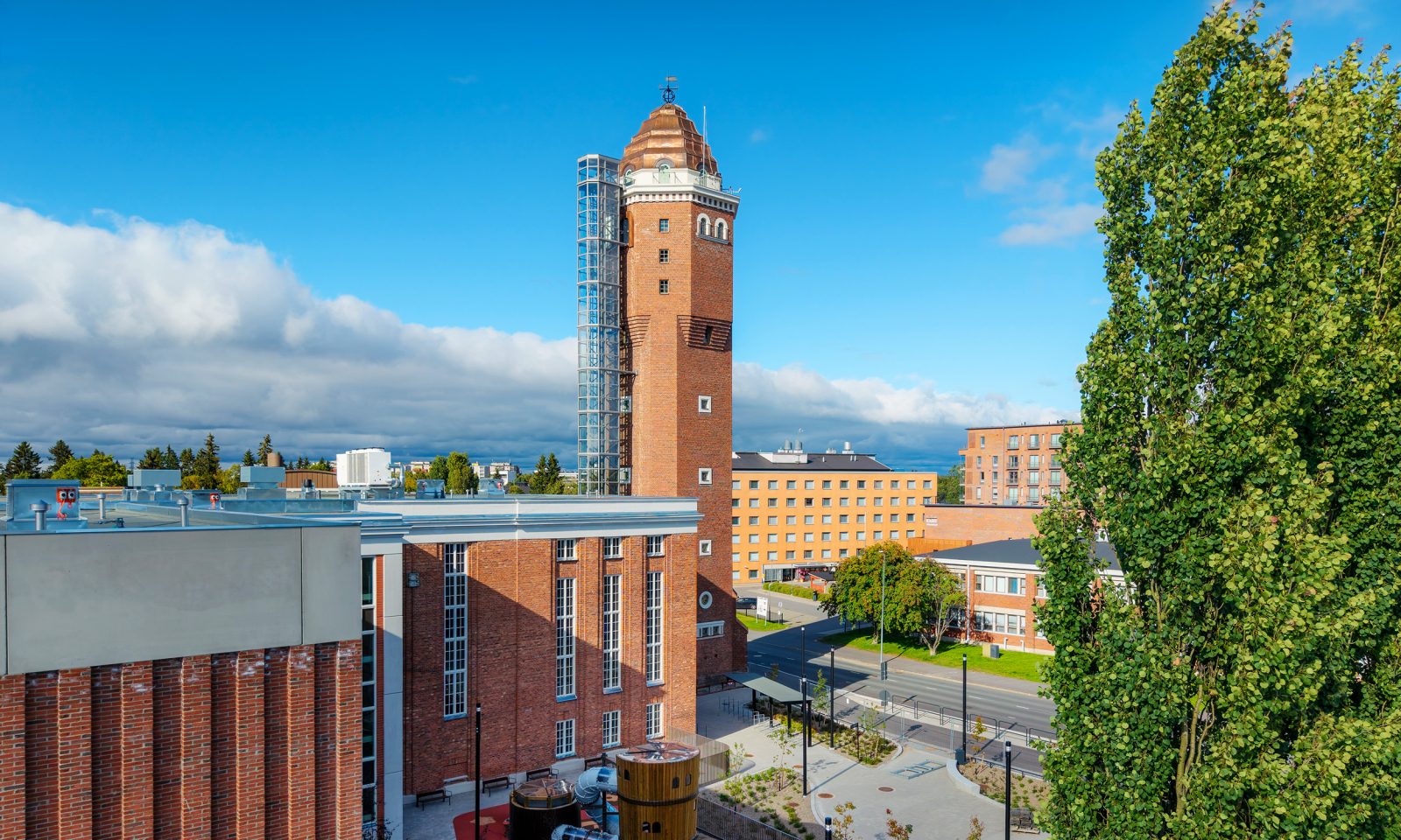Museo- ja tiedekeskus Tiima Oulussa aurinkoisena päivänä. Kuvassa näkyvät Tiiman uusi museorakennus sekä Tiimaan kuuluva entisen Tiedekeskus Tietomaan punatiilinen rakennus ja torni.