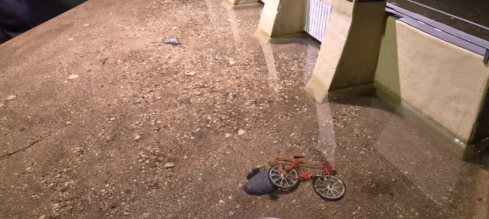Pato ja joen pohjalla oleva polkupyörä valettuna epoksiin.