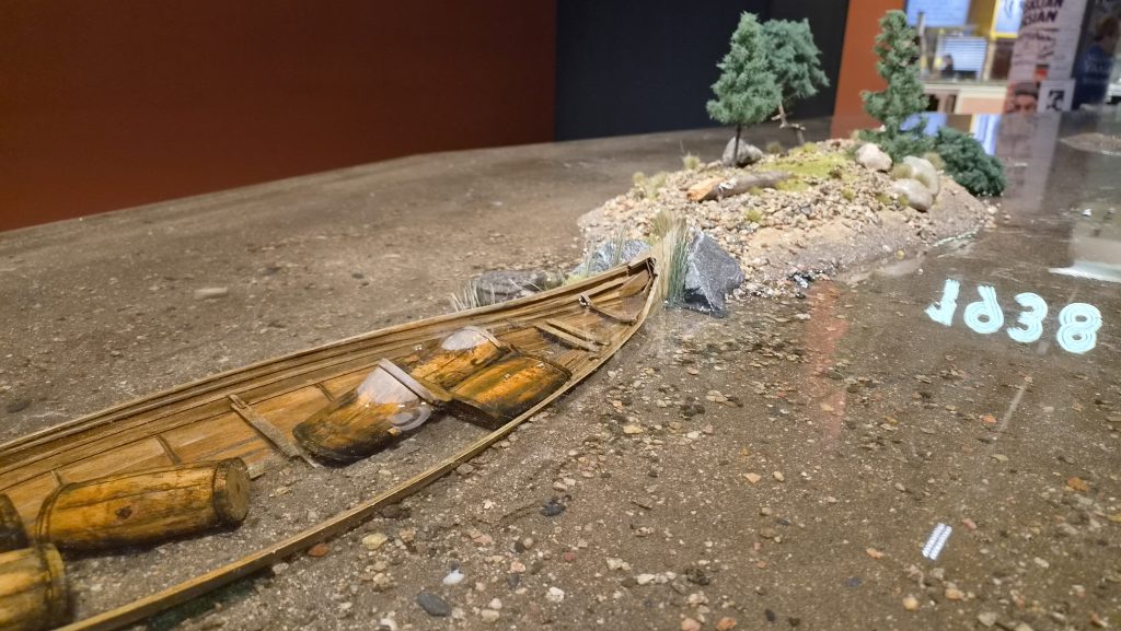 Tervatynnyreillä täytetty vene ja pieni saari valettuna epoksiin.